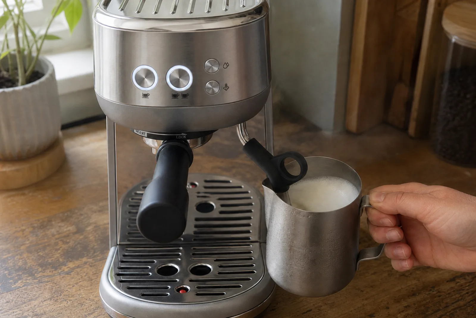 A Breville Bambino BES450 actively steaming milk in a small stainless pitcher
